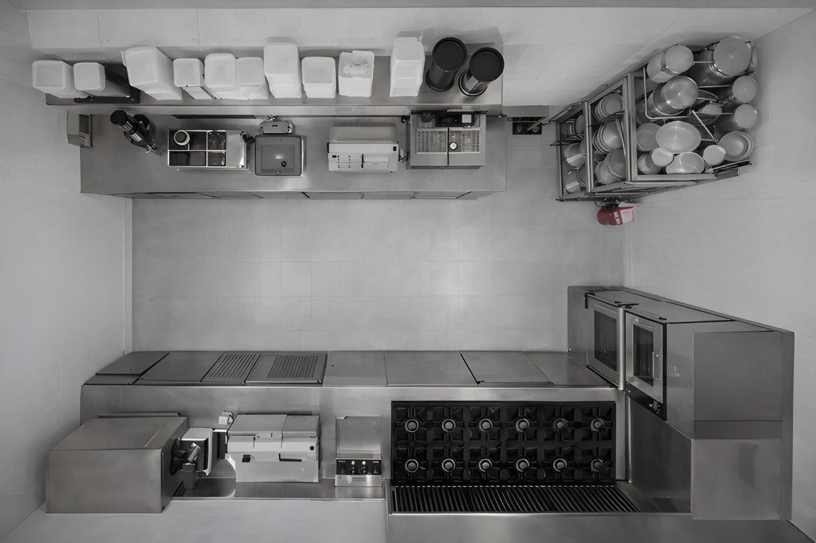 Cozinha vista de cima com bancadas, pias e prateleiras em aço inox